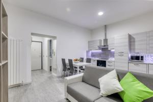 a living room with a couch and a kitchen at Tourist Apartment Civitavecchia in Civitavecchia
