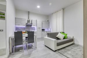 a kitchen and dining room with a couch and a table at Tourist Apartment Civitavecchia in Civitavecchia