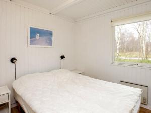 a white bedroom with a bed and a window at Three-Bedroom Holiday home in Læsø 4 in Læsø