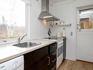 a kitchen with a sink and a stove and a window at 6 person holiday home in Læsø-By Traum in Læsø +13 photos