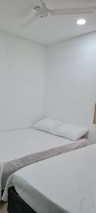 a white bed sitting in a room with at Hermosa casa en Santa Marta! (Conjunto Cerrado) in Santa Marta
