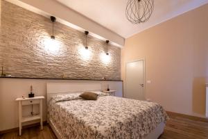 1 dormitorio con cama y pared de ladrillo en San Miniato - Terrazza panoramica in centro storico en San Miniato