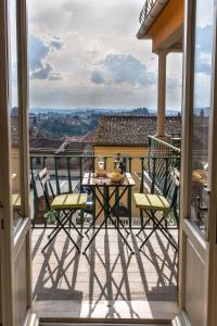聖米尼亞托的住宿－San Miniato - Terrazza panoramica in centro storico，阳台的天井配有桌椅