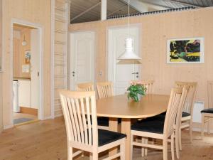 OksbølにあるThree-Bedroom Holiday home in Oksbøl 17のキッチン、ダイニングルーム(木製のテーブルと椅子付)