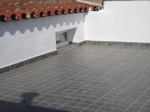 een terras met een tegelvloer en een witte muur bij Casa da Avó in Redondo