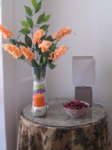 een tafel met een vaas met oranje bloemen en een kaars bij Casa da Avó in Redondo