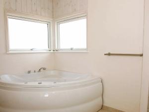 ロンストラップにある6 person holiday home in Hj rringの白いバスルーム(バスタブ付)、窓が備わります。