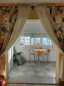 jadalnia ze stołem, krzesłami i oknami w obiekcie Precioso apartamento w mieście El Portil