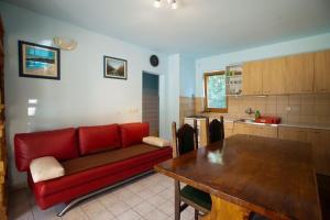 uma sala de estar com um sofá vermelho e uma mesa em One-bedroom apartment with terrace in Povile 3542-3 em Povile