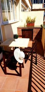 托雷莫利諾斯的住宿－Apartamento Blancomar，坐在庭院里的桌子和帽子