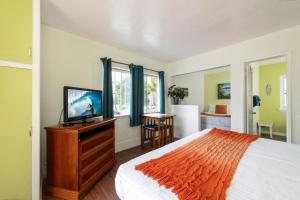 a bedroom with a bed and a flat screen tv at The Patriots Boutique Motel in San Clemente