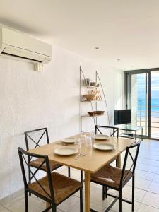 a dining room with a wooden table and chairs at Apartamentos Stella Maris in Roses