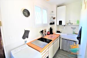 eine kleine Küche mit einer Spüle und einer Theke in der Unterkunft Hyères-plage Studio cabine-L'ayguade BY HC in Hyères