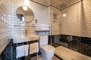 a bathroom with a toilet and a sink and a mirror at The Park Hotel in Teddington