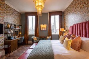 a hotel room with a large bed and a desk at The Park Hotel in Teddington
