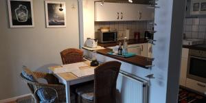 a kitchen with a table with chairs and a counter top at FeWo Auszeit in Harrislee