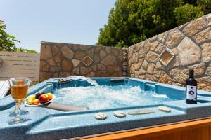 a hot tub with a bottle of wine and a glass at Fiorentinos Villa in Tragaki