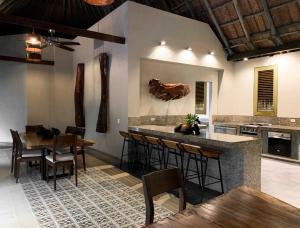 a kitchen with a bar and some tables and chairs at Casa Bambu Tayrona, Los Naranjos in Los Naranjos