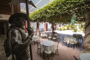 a statue of a man holding an umbrella in a restaurant at La Casa del Marqués in Comitán