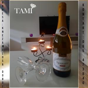a bottle of champagne sitting on a table with candles at Apartman Tami in Doboj