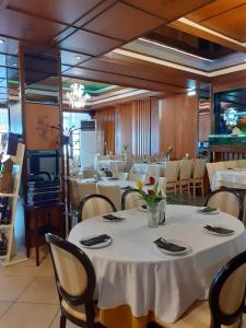 a dining room with tables and chairs with white table cloth at Hotel Zografos in Paralia Katerinis