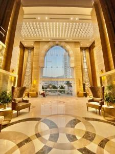 a large lobby with chairs and a large window at Afraa Hotel Al Aziziya in Makkah
