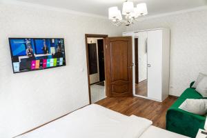 カリーニングラードにあるApartment Elegantのリビングルーム(ベッド1台、壁掛けテレビ付)