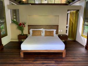 1 dormitorio con 1 cama grande con sábanas y almohadas blancas en Casa Bambu Tayrona, Los Naranjos en Los Naranjos