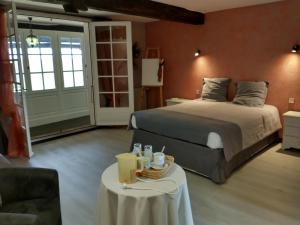 Un dormitorio con una cama y una mesa con bebidas. en Domaine Sainte Barthe, entre Marciac et Nogaro, en Aignan
