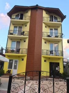 un edificio alto con balcones, mesas y sillas en Villa Ureki en Ureki