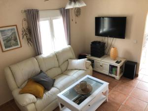 a living room with a white couch and a tv at Sonniges Apartment an der Costa Blanca in San Fulgencio