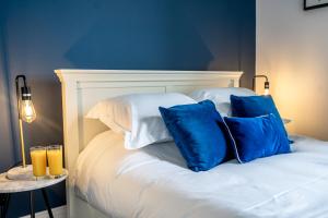 a bed with blue and white pillows on it at 5 Rowntree House in York
