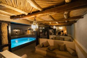 a living room with a swimming pool and a couch at Kasbah Mohayut in Merzouga