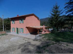 une petite maison rose avec un arbre devant elle dans l'établissement La Casetta, à Marcoiano