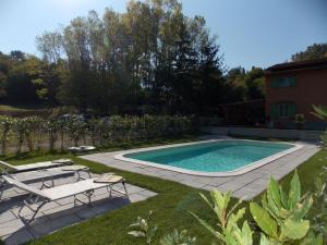 una piscina en un patio con sillas y una casa en La Casetta en Marcoiano