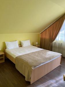 - une chambre avec un grand lit et une fenêtre dans l'établissement Casa Albert Valea Avrigului, à Avrig