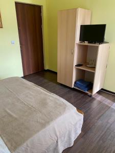 - une chambre avec un lit et une télévision sur une armoire dans l'établissement Casa Albert Valea Avrigului, à Avrig