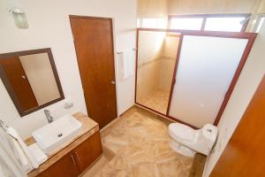 a bathroom with a toilet and a sink and a mirror at Villas Najo' Isla Mujeres. in Isla Mujeres +18 photos