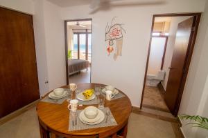 a dining room with a wooden table in a room at Villas Najo' Isla Mujeres. in Isla Mujeres