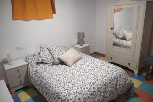 a bedroom with a bed and a mirror at LOS ORIZOS Sierra de Gata Extremadura TR-CC-00392 in Villamiel