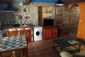 a kitchen with a washer and dryer in a room at LOS ORIZOS Sierra de Gata Extremadura TR-CC-00392 in Villamiel