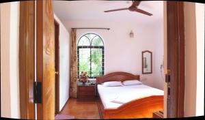 a bedroom with a bed and a window at Albuquerque BetterHomes, Goa in Candolim +20 photos