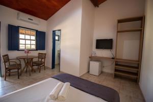 ピレノポリスにあるPousada Vereda da Serraのベッドルーム(ベッド1台、テーブル、テレビ付)