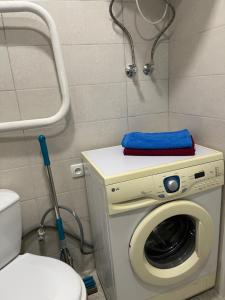 a bathroom with a washing machine and a toilet at Апартаменты на ГОГОЛЯ,460 in Cherkasy