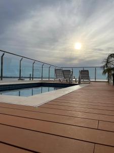 eine Terrasse mit Stühlen und ein Pool auf einem Gebäude in der Unterkunft Monoambiente a 400 metros de la playa in Encarnación