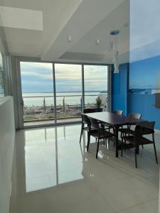 comedor con mesa y sillas y ventana grande en Monoambiente a 400 metros de la playa, en Encarnación