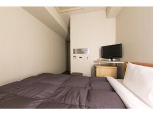 a bedroom with a bed and a flat screen tv at R&B HOTEL NAGOYA SAKAE HIGASHI - Vacation STAY 14030v in Nagoya