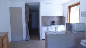 a kitchen with white cabinets and a counter top at QUEYRAS in Ceillac