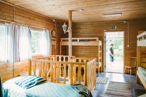 a bedroom with wooden walls and a bunk bed at Riihon Majatalo in Riiho