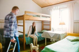 a man standing in a bedroom with a girl sitting on a bunk bed at Riihon Majatalo in Riiho